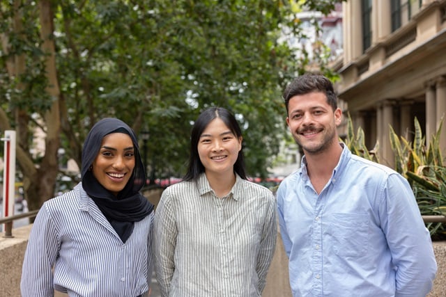 Three City of Sydney employees smile while standing outside on a clear day.