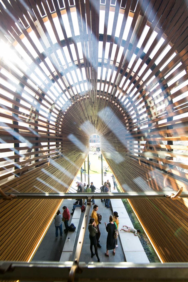 From the mezzanine level looking down are people and above is a curved roof.
