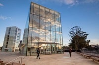 Two people walking past a building