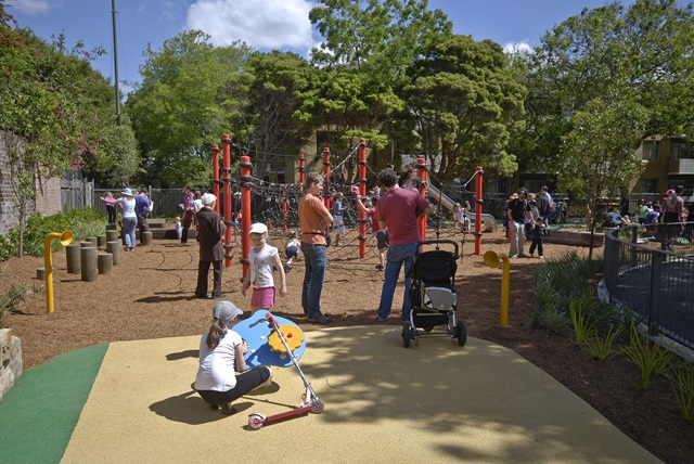 Adults watching their children play in a playground.