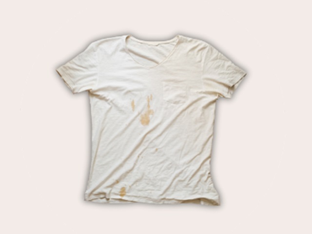 An old white stained tshirt on a cream background